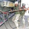 1200px-US_Navy_030730-N-9455K-103_Seabees_use_a_breaker_bar_to_secure_a_bulldozer_before_transporting_it_to_Camp_Moreell_from_Camp_Castle